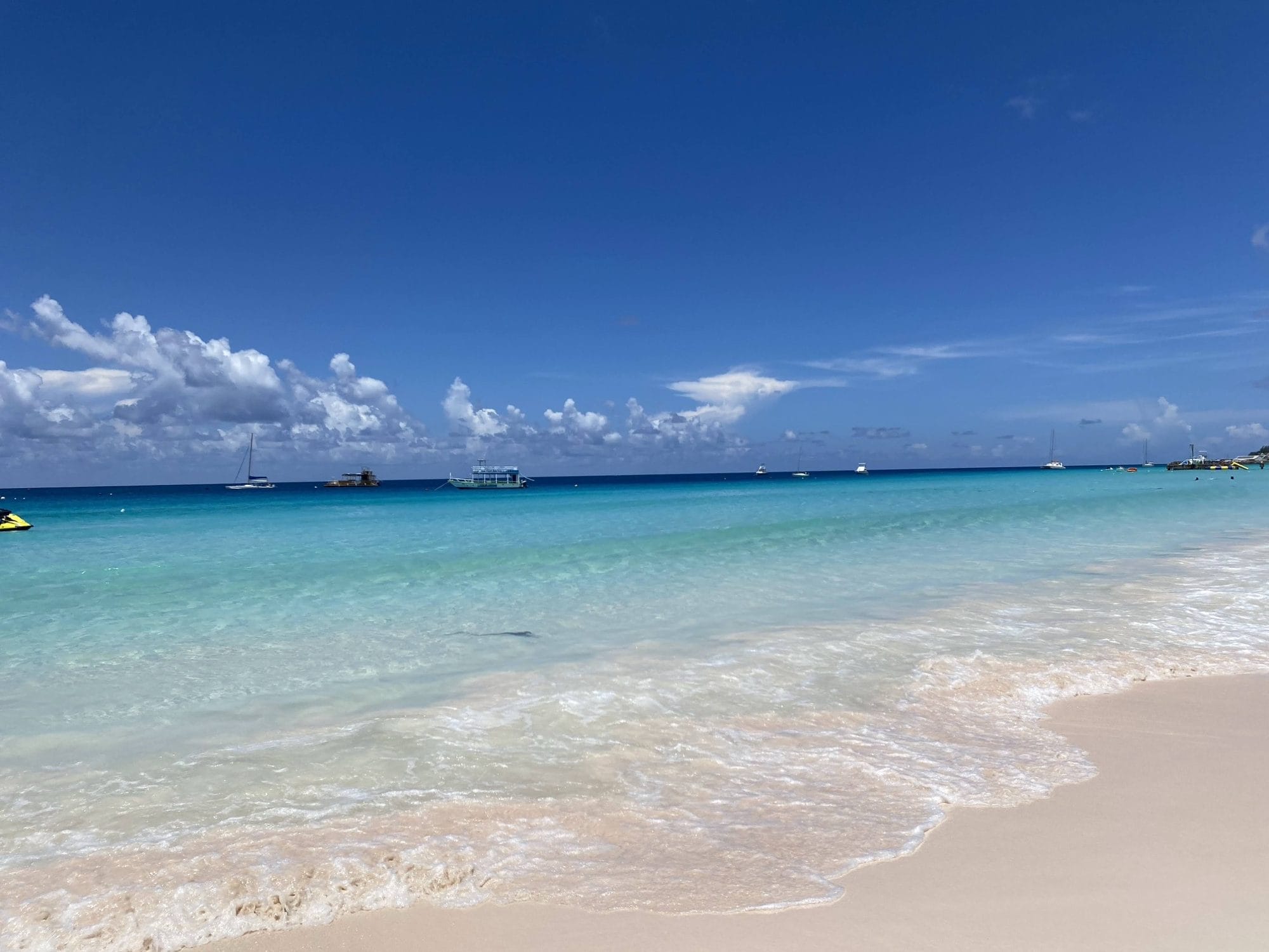 A quiet Barbados beach — turquoise water under a bright sky